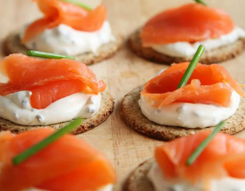 White sauce and salmon pieces on bread