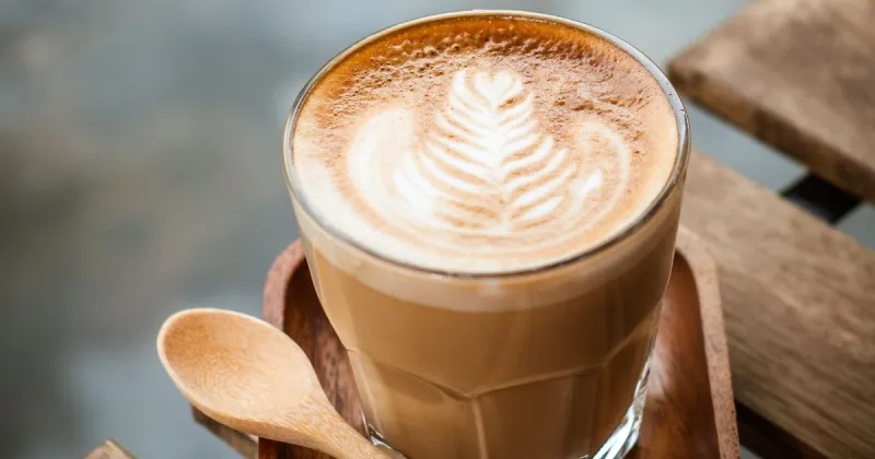 Glass of latte on table