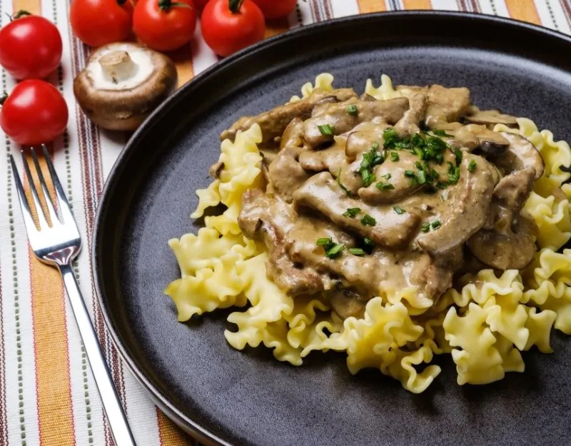 beef stroganoff with sour cream served on pasta
