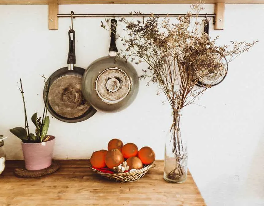 Two gray frying pans hanging on wall