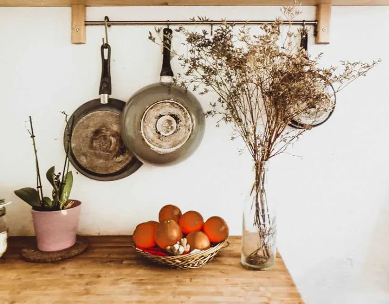 Two gray frying pans hanging on wall