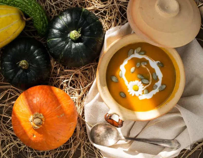 Butternut soup on white pot and vegetables