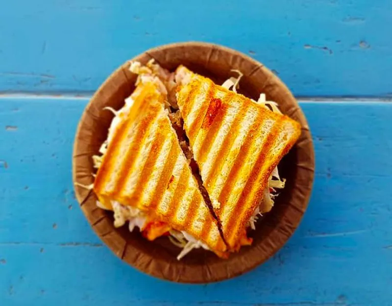 Grilled cheese sandwich on a wooden plate and blue table