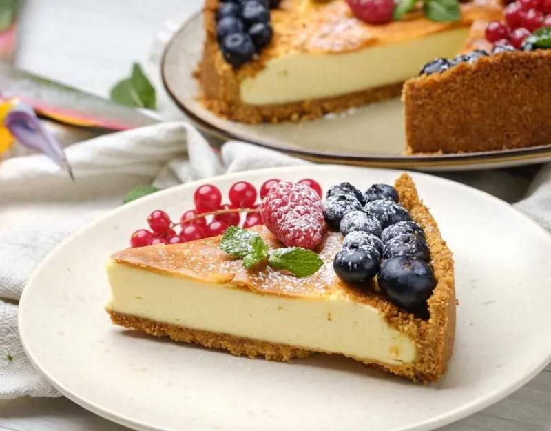 Üstünde çilek ve dut olan bir dilim cheesecake