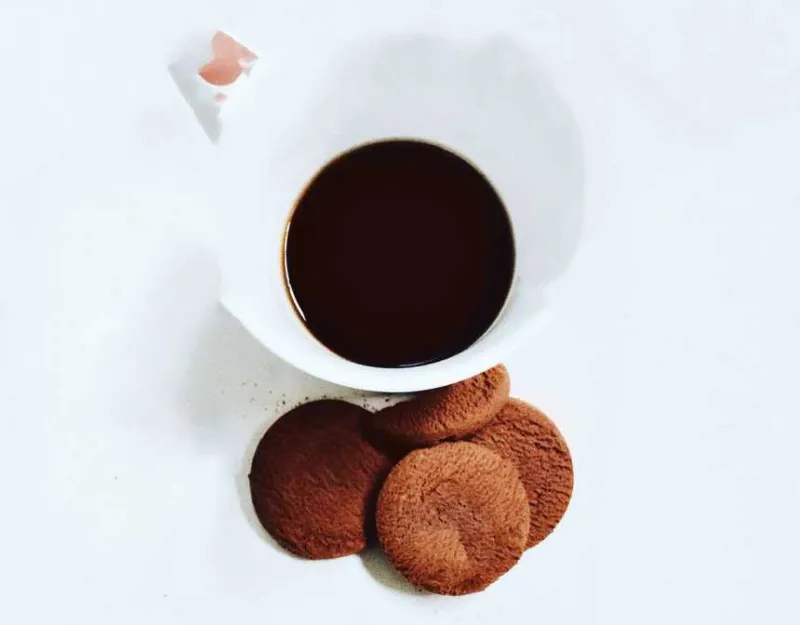 Beyaz seramik mug yanında dört kurabiye